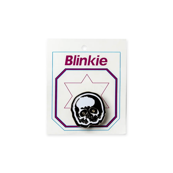 Skull-shaped Blinkie badge on packaging for the Light Up Skully Pin product